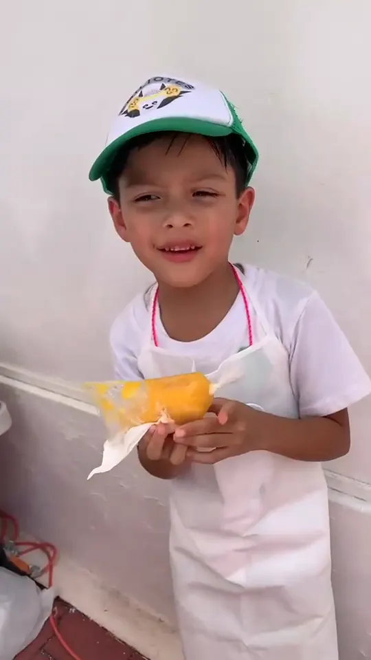 Emilio sonríe sosteniendo dos bolsas de esquites en su primer Business Fair